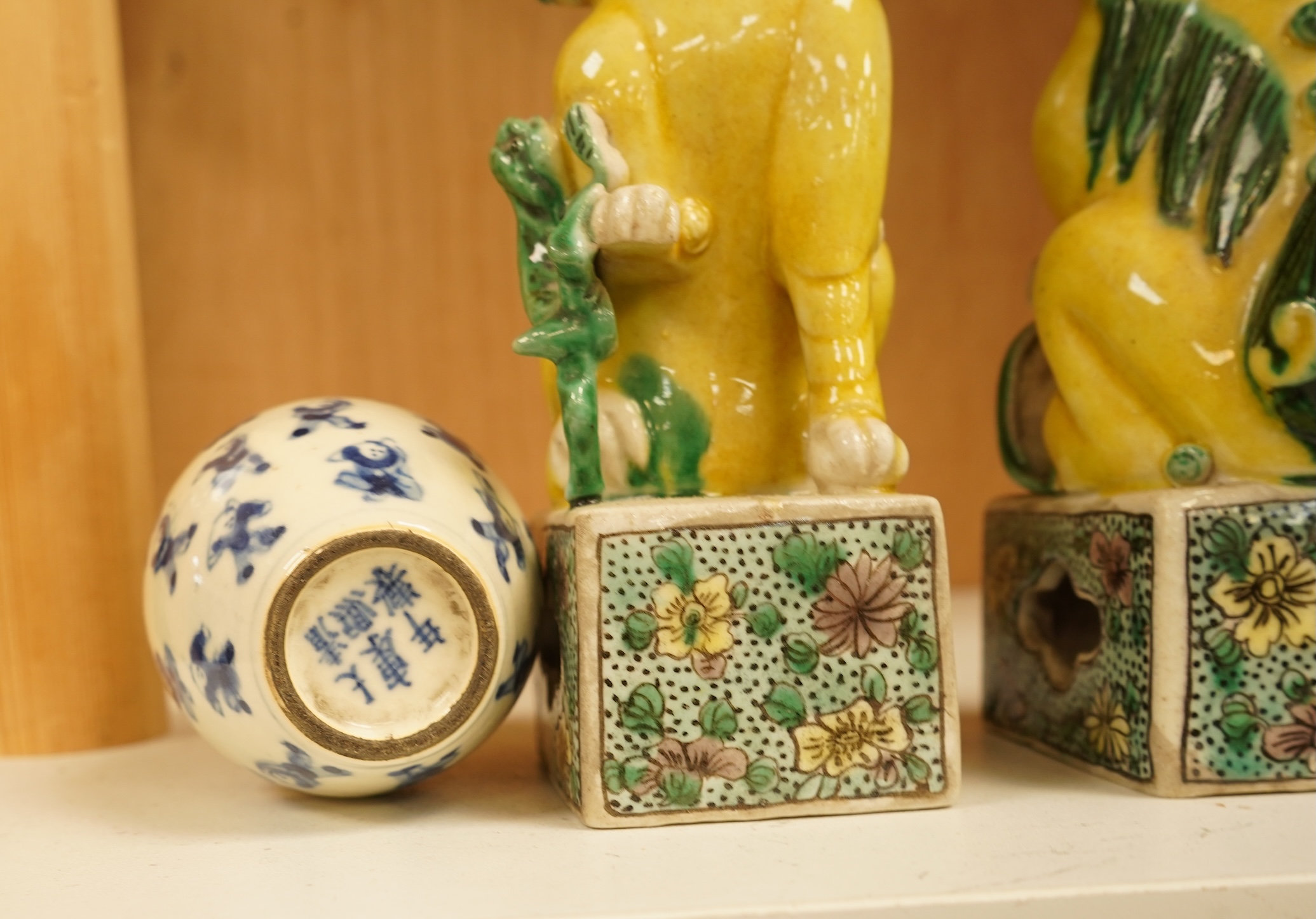 A pair of late 19th/early 20th century Chinese famille verte lion dogs and a similar pair of blue and white miniature ‘boys’ jars and covers, 15cm